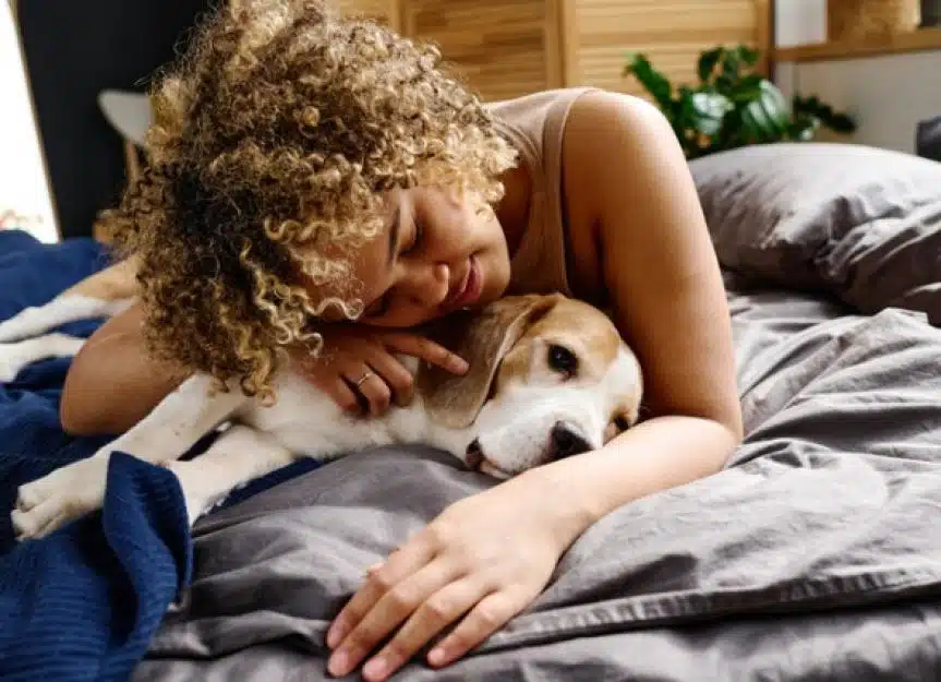 woman cuddling with dogs on bed picture id1394774841